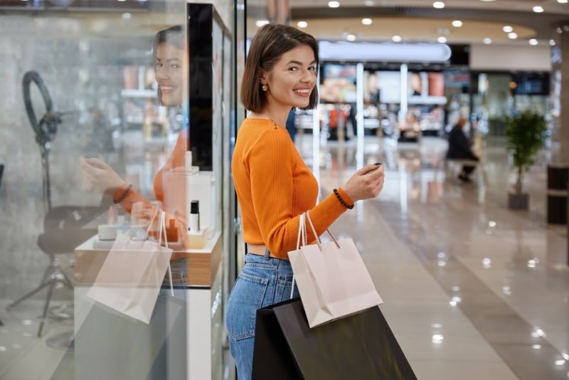 Maui Shopping: A woman smiles while she carries shopping bags through a West Maui mall.