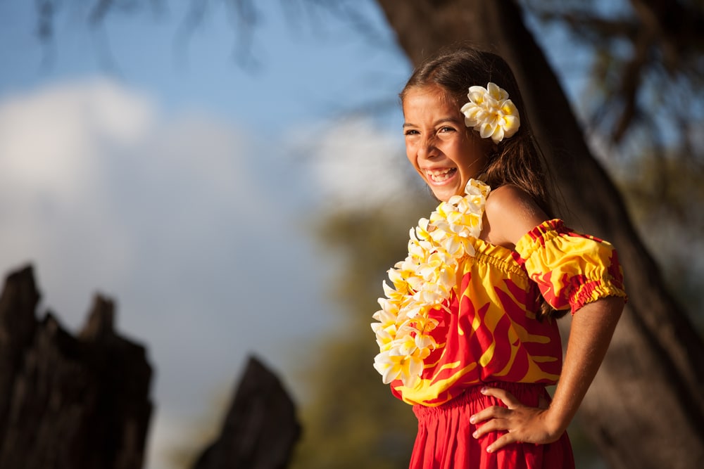 Hawaii Lei: A young girl smiles as she basks in the sun while wearing a pretty yellow lei.